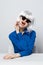 cheerful glamorous Woman in a White wig sits at the table with emotion blue shirt