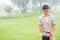 Cheerful golfer smiling at camera holding golf bag