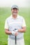 Cheerful golfer smiling at camera holding his club