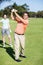 Cheerful golfer taking shot