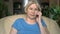 Cheerful good-looking senior woman sitting in chair at home. Talking on her smartphone