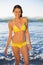 Cheerful gorgeous woman in yellow bikini bathing in the sea