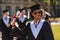 Cheerful graduant raising hand with his diploma.