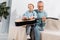 cheerful grandfather playing with grandson on knees playing on acoustic guitar