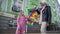 Cheerful grandmother and granddaughter holding colorful Kite standing on urban city street talking. Portrait of happy