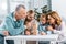 cheerful grandparents and grandchildren playing blocks wood tower game together