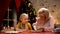 Cheerful granny and girl decorating cookies for Christmas party, happy holidays