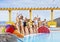 Cheerful group of eight beautiful female friends standing close to the swimming pool  with inflatable mattress. Bikini and