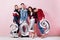 Cheerful group of friends of two girls and two guys dressed in stylish clothes are holding balloons in the shape of