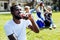 Cheerful guy smiling while drinking soda outdoors