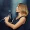 Cheerful hairdresser, woman posing with a Hairdryer in her hands