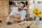 Cheerful handicraftsman working near the vase with sunflowers