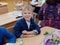 Cheerful handsome first-grader boy at his desk at school