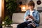 A cheerful handsome teenage boy chats with his friends on his smartphone during a break in his English studies. A young