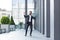 Cheerful happy business man dancing walk the city street background a modern office building outside, outdoors Funny successful