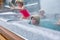 Cheerful happy family with children enjoys hot bath in jacuzzi whirlpool on cold winter day. Carefree relaxation in hot