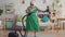 Cheerful happy old woman pensioner with gray hair in glasses playing a vacuum cleaner like a guitar slow mo