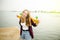 Cheerful happy skater girl in hipster outfit having fun on a wooden pier during summer vacation