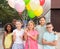 Cheerful happy tween children with colorful balloons on city street