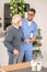 Cheerful healthcare worker supporting an old man with a cane