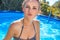 Cheerful healthy woman in swimming pool kiss on camera