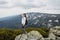 Cheerful hiker girl with dark hair on high mountains background in summertime