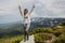 Cheerful hiker girl with dark hair on high mountains background in summertime