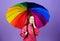 Cheerful hipster child in positive mood. Small girl in raincoat. autumn fashion. rain protection. Rainbow. happy small