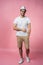 Cheerful hipster guy smiles happily, has excited expression, dresssed casually isolated over pink studio background