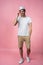 Cheerful hipster guy smiles happily, has excited expression, dresssed casually isolated over pink studio background