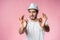 Cheerful hipster guy smiles happily, has excited expression, dresssed casually isolated over pink studio background