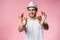 Cheerful hipster guy smiles happily, has excited expression, dresssed casually isolated over pink studio background