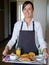 Cheerful hotel maid serving breakfast