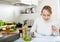 Cheerful housewife signing papers in kitchen