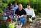 Cheerful international family with harvest of vegetables on the plantation