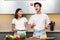 Cheerful Japanese Couple Cooking Having Fun Juggling Fruits In Kitchen