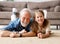 Cheerful kid girl with grandfather lying on the floor at home