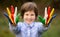 Cheerful kid girl show hello gesture with hands painted in Seychelles flag colors. Focus on hands