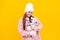 cheerful kid in winter hat with toy. teen girl in mittens hold toy present on yellow background