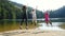 Cheerful kids jumping and enjoying during the summer vacation on a forest lake