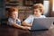 Cheerful kids playing on laptop together