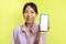 Cheerful Korean Lady Holding Cellphone Blank Screen Over Yellow Background