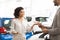 Cheerful Lady Customer Talking With Auto Seller Standing In Dealership