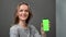 Cheerful lady demonstrate mobile phone green screen chroma key smartphone. 4k Dragon RED camera