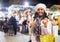 Cheerful Latina looking for New Year decorations in street market