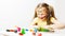 cheerful  laughing caucasian preschool little girl painting picture draws with fingers on white background.