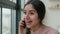 Cheerful laughing Indian Arabian girl gen z student speak mobile phone at office casual carefree conversation happy