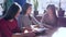 Cheerful leisure, company of woman choose food from menu sitting at table in cafe