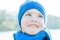 Cheerful little boy close-up portrait with blue knitted hat