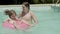 Cheerful little boy floating on inflatable ring in swimming pool